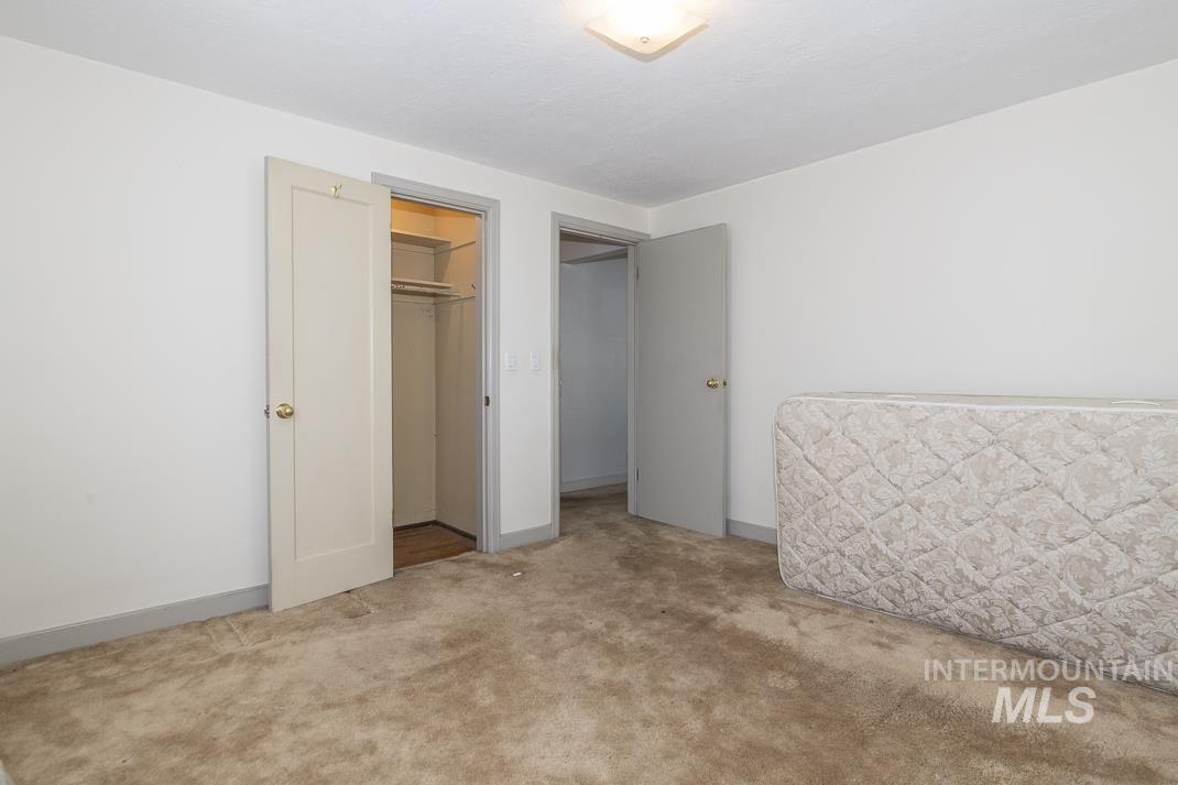 Unfurnished bedroom with carpet and a walk in closet
