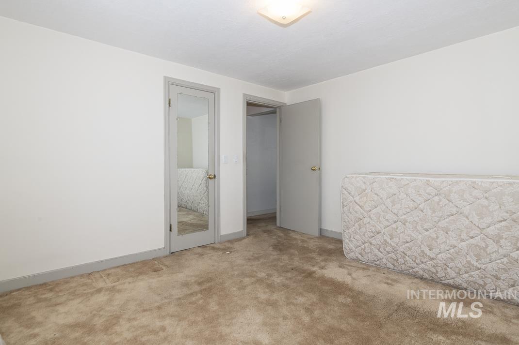 Unfurnished room featuring light colored carpet and baseboards