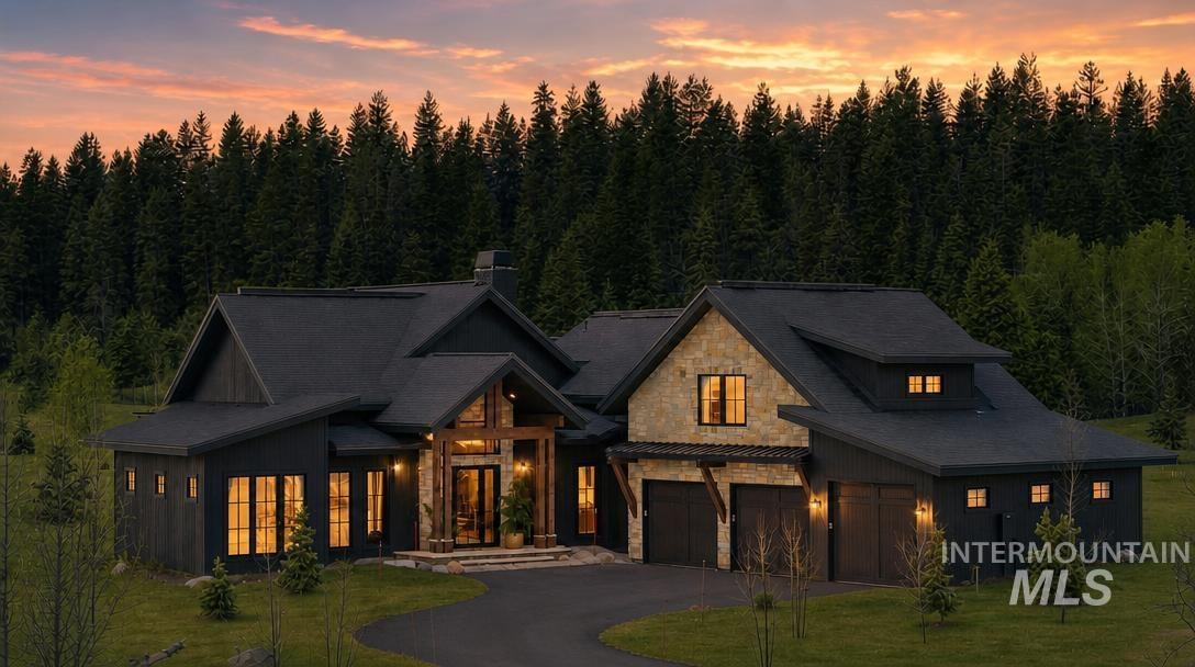 Modern lodge-style exterior featuring dark siding, stone accents, and a multi-gabled roofline