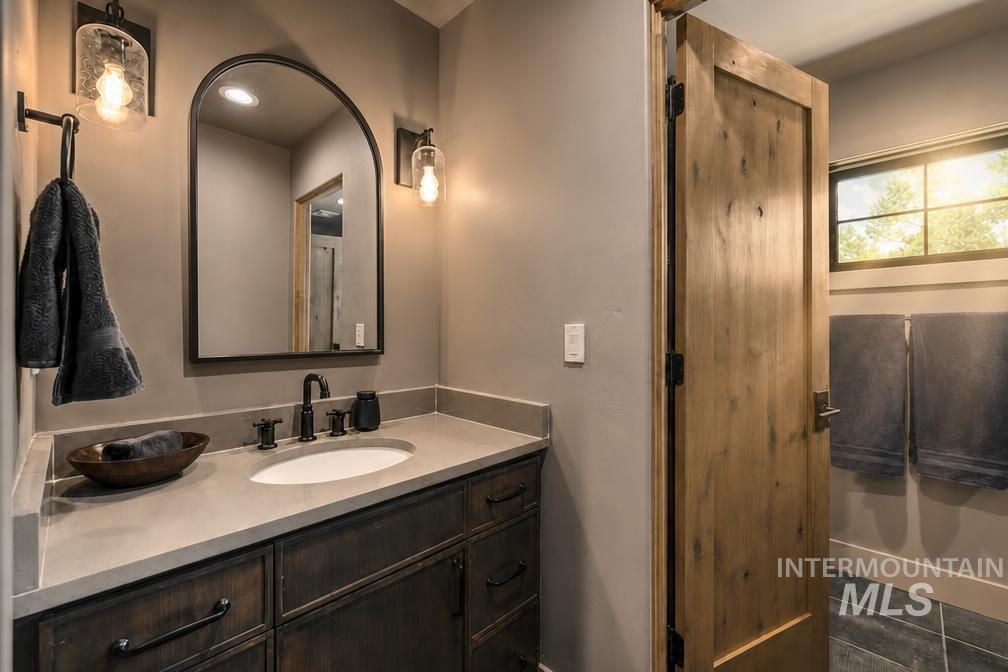 Bathroom vanity featuring a dark wood-finish cabinet, light countertop, and oval undermount sink