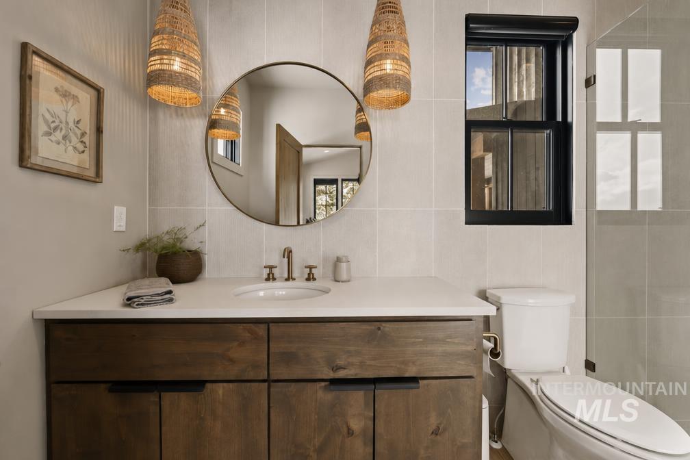 Bathroom featuring a dark wood-finish vanity with a white countertop and round mirror