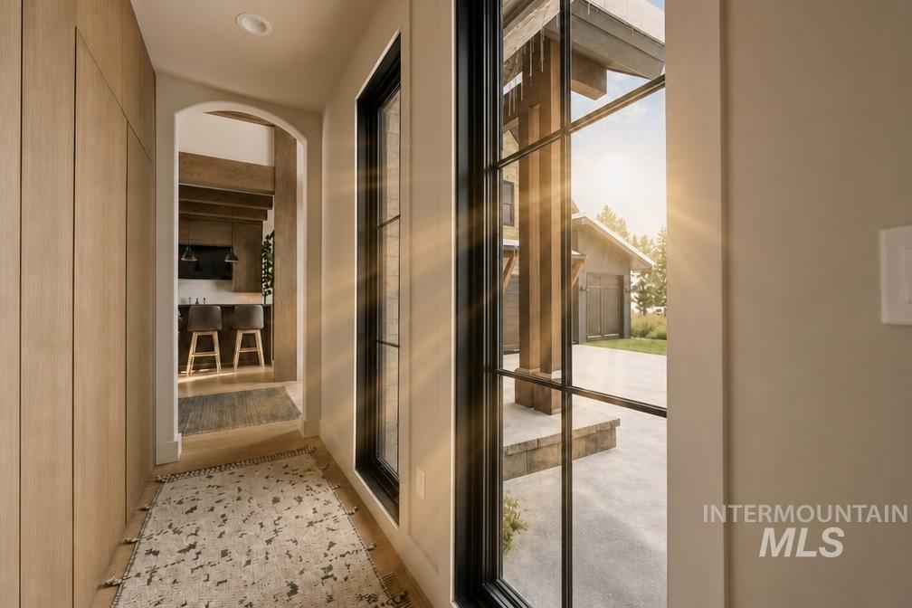 Entryway featuring wood-finish paneling, an arched doorway, and recessed lighting