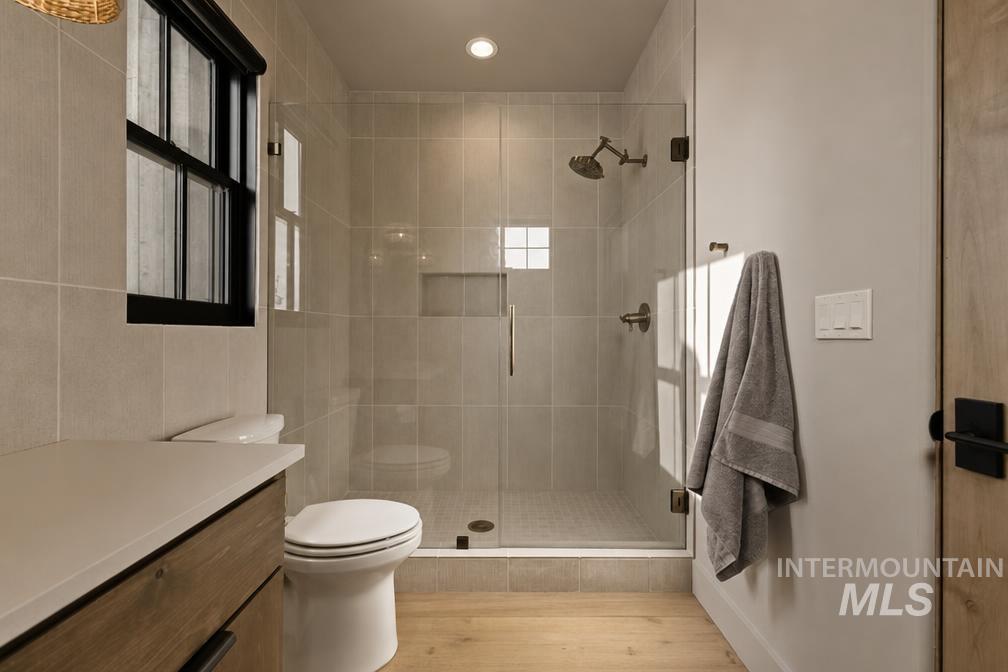 Modern bathroom featuring a glass-enclosed shower with light-toned wall tiling, a built-in shower niche, and bronze fixtures