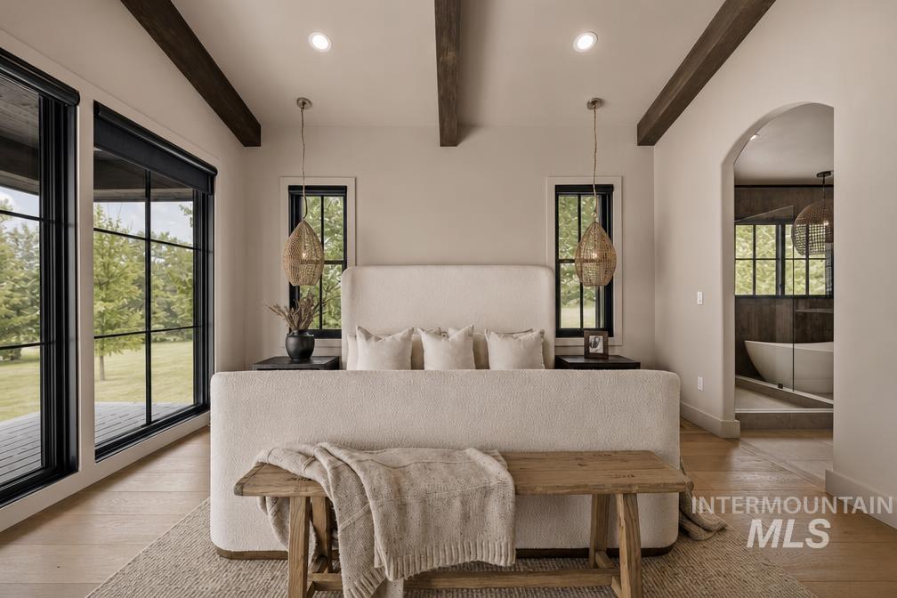 Spacious room with wood-finish flooring, exposed ceiling beams, and recessed lighting