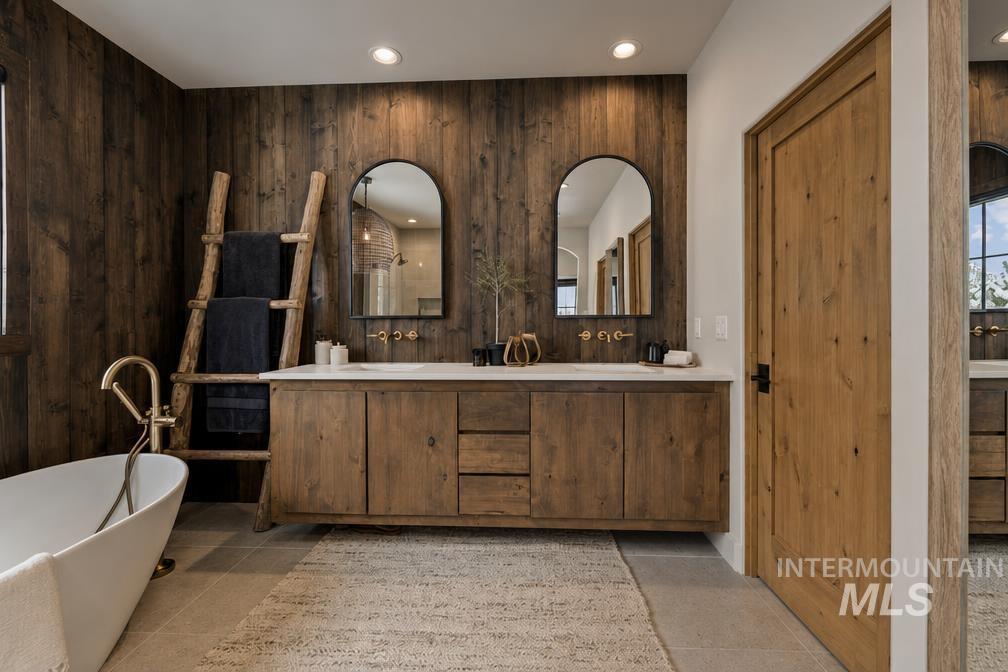 Dual vanity with wood-finish cabinetry and white countertops set against a wood-paneled accent wall