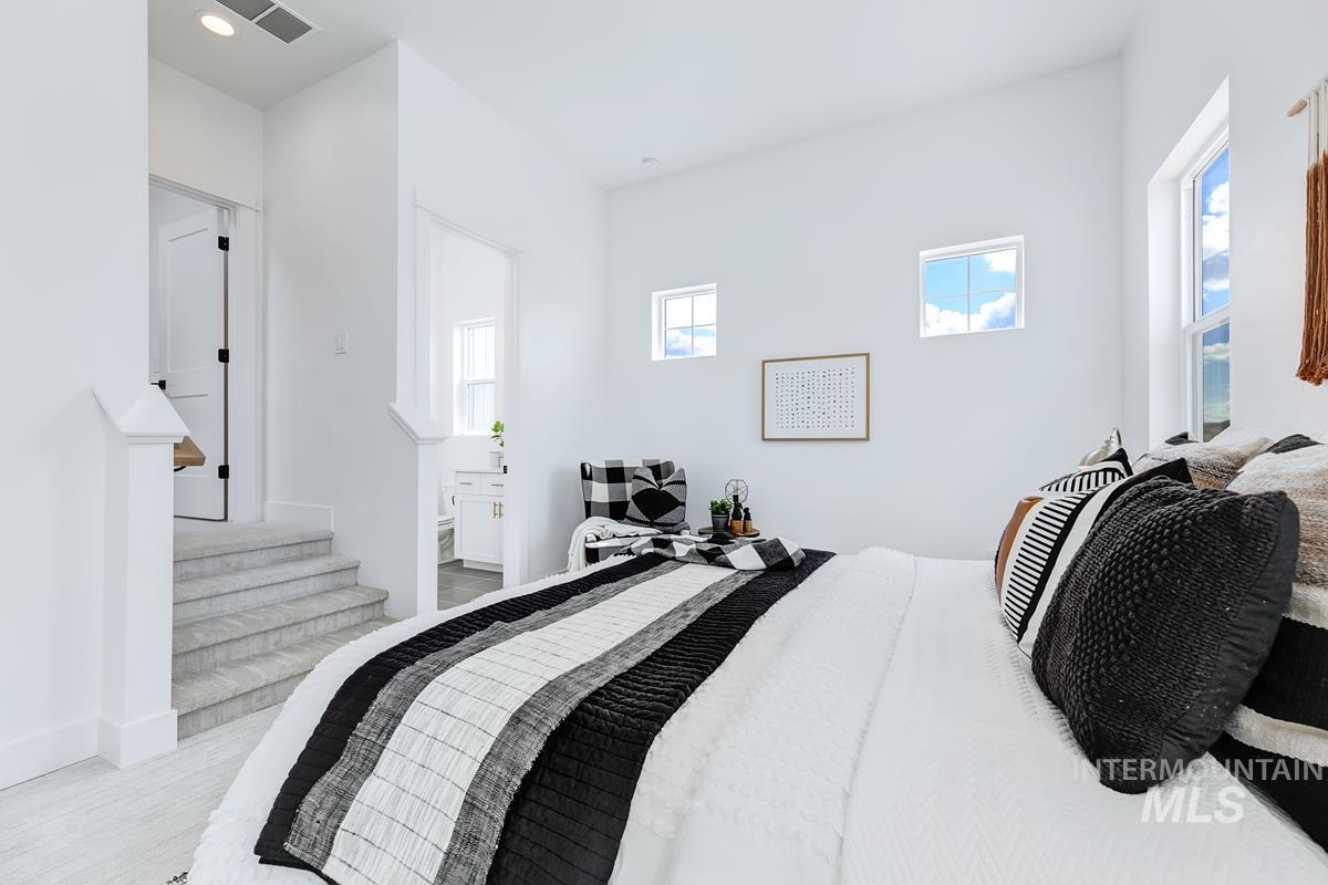 Bedroom featuring ensuite bath and light wood-style floors