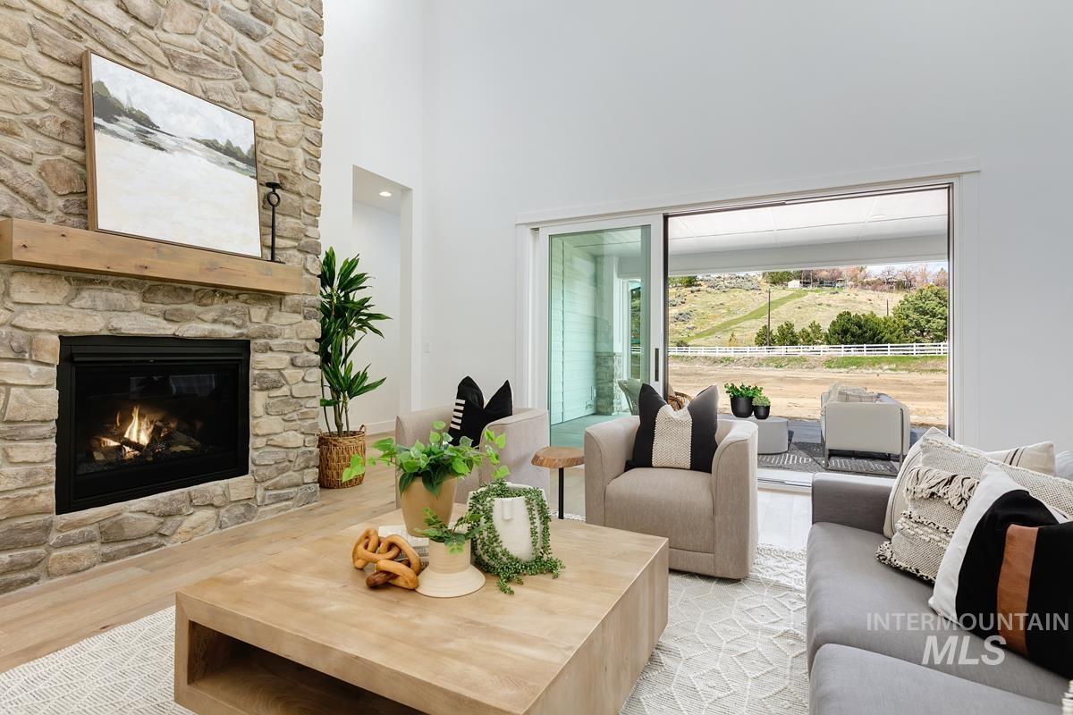 Living area with a fireplace, a high ceiling, and light wood finished floors