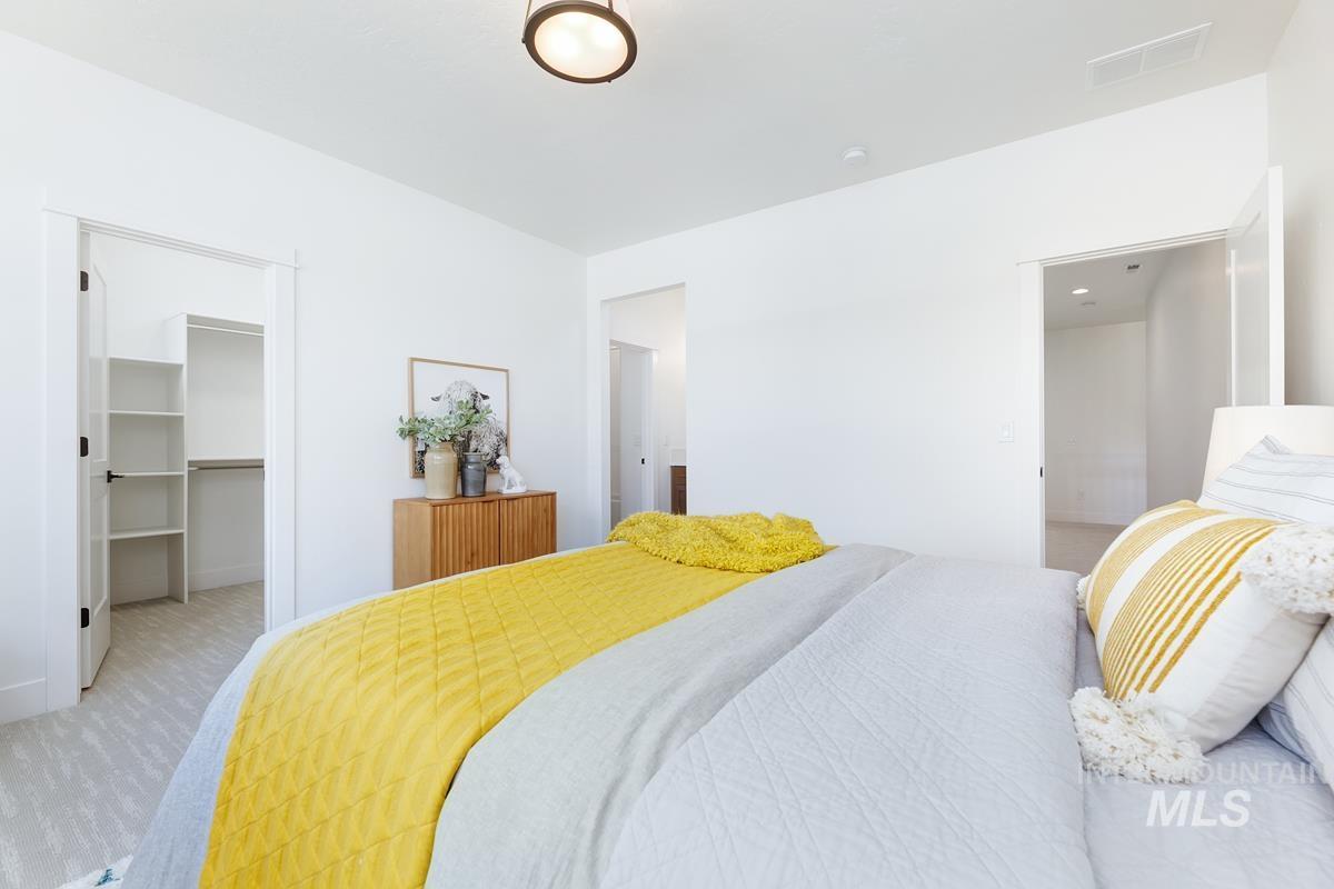 Bedroom with carpet and a walk in closet