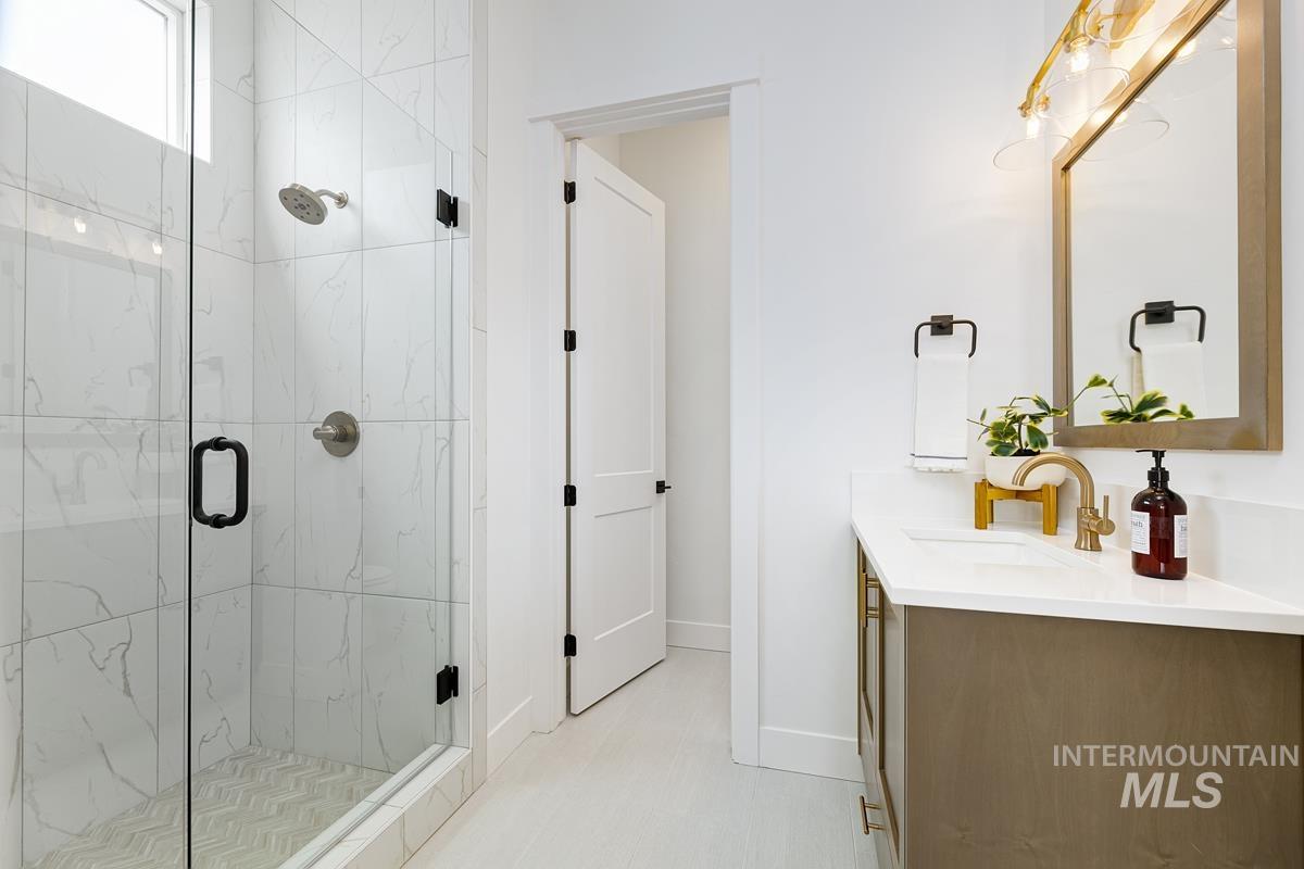 Bathroom with vanity and a marble finish shower