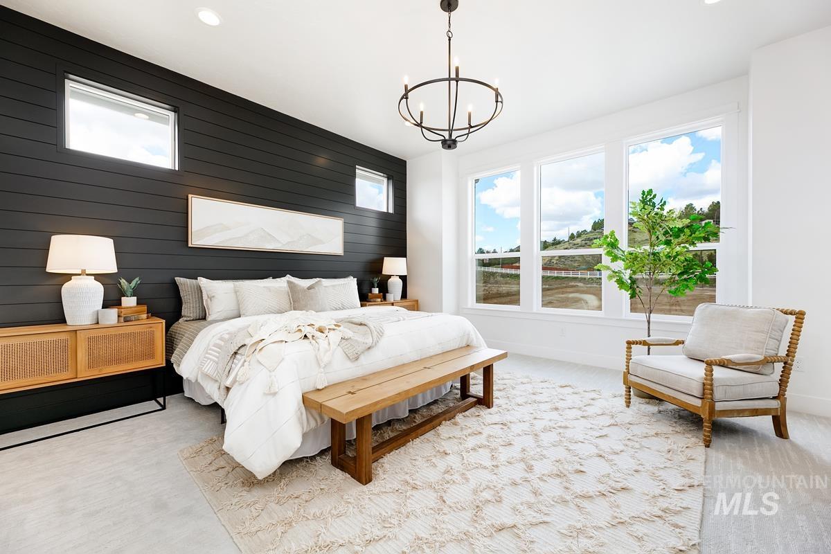 Carpeted bedroom featuring wooden walls, multiple windows, an accent wall, a chandelier, and recessed lighting
