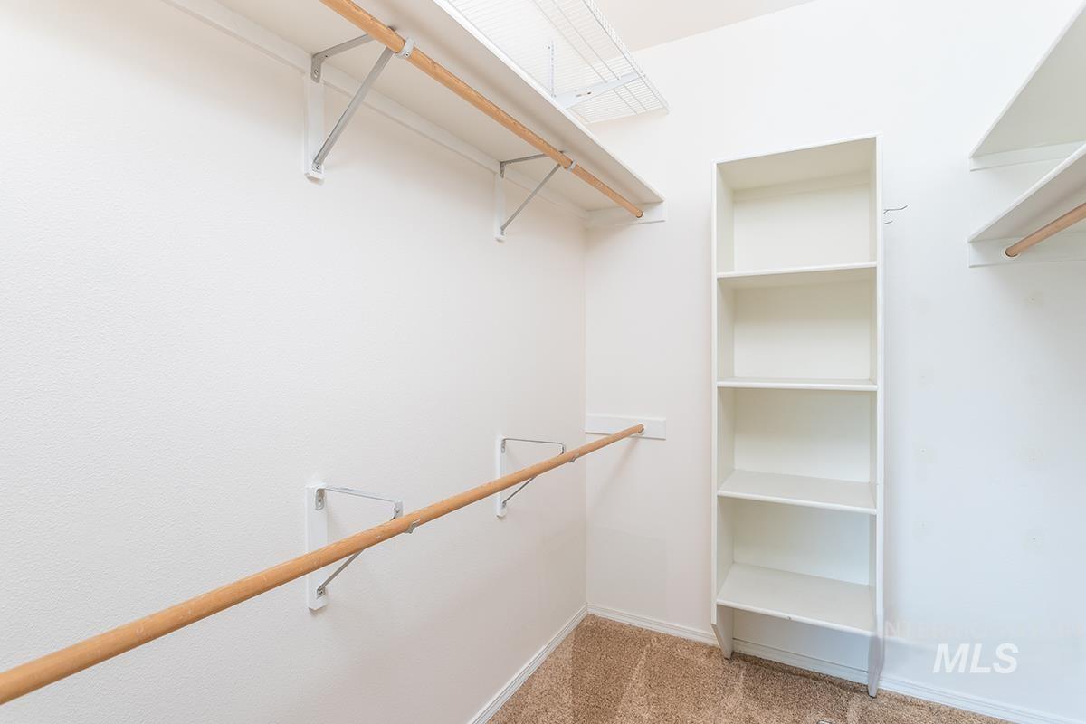 Walk in closet featuring light colored carpet