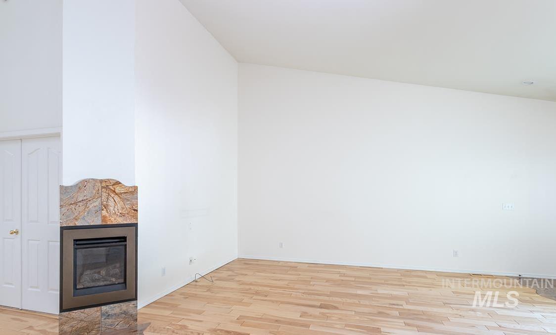 Unfurnished living room featuring light wood-style floors and a tile fireplace