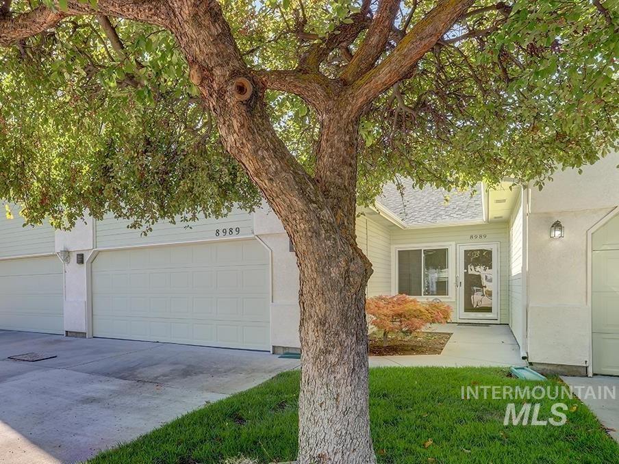 View of front facade featuring driveway, an attached garage, and stucco siding