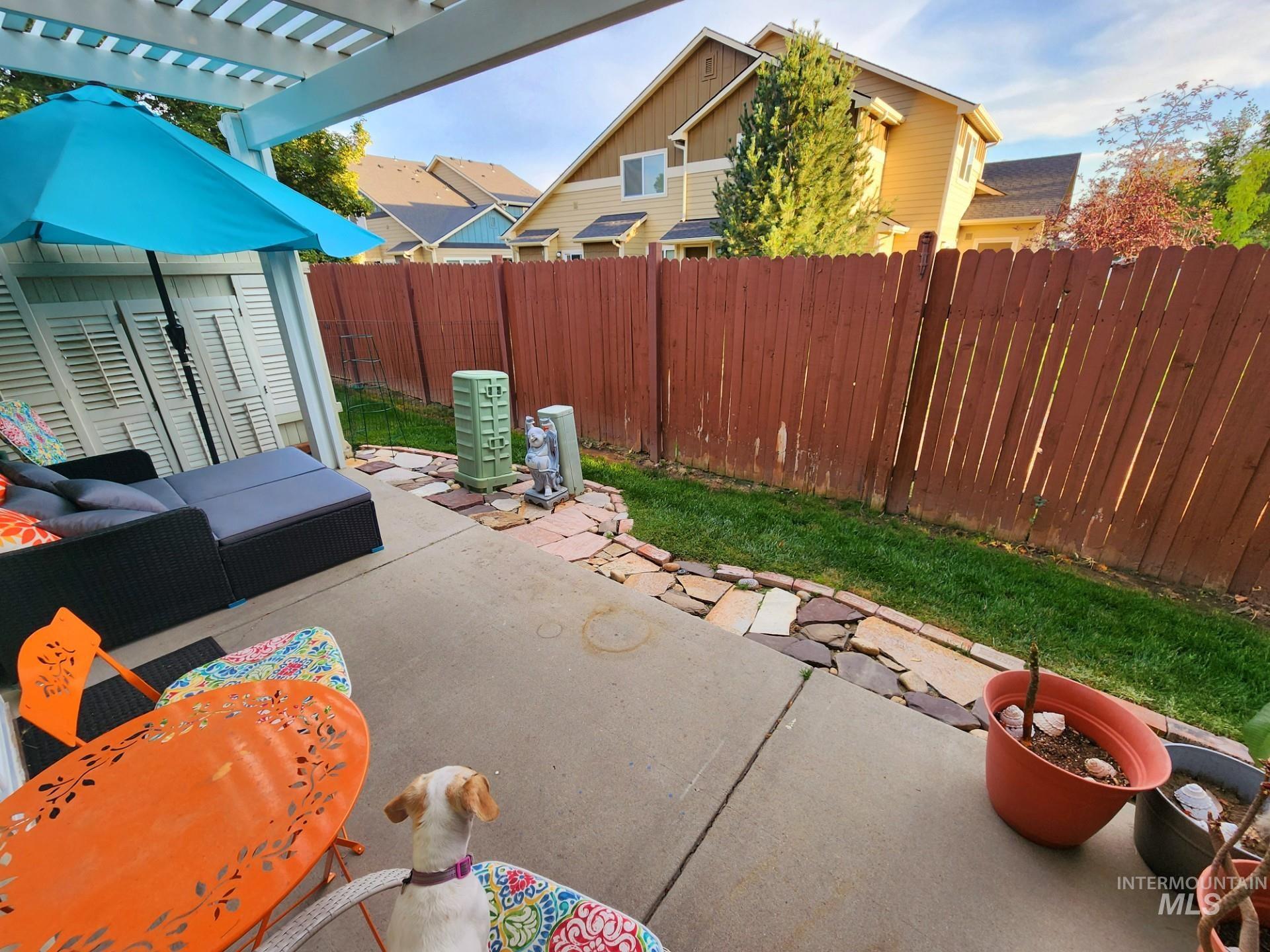Fenced backyard featuring a patio, a pergola, and an outdoor hangout area