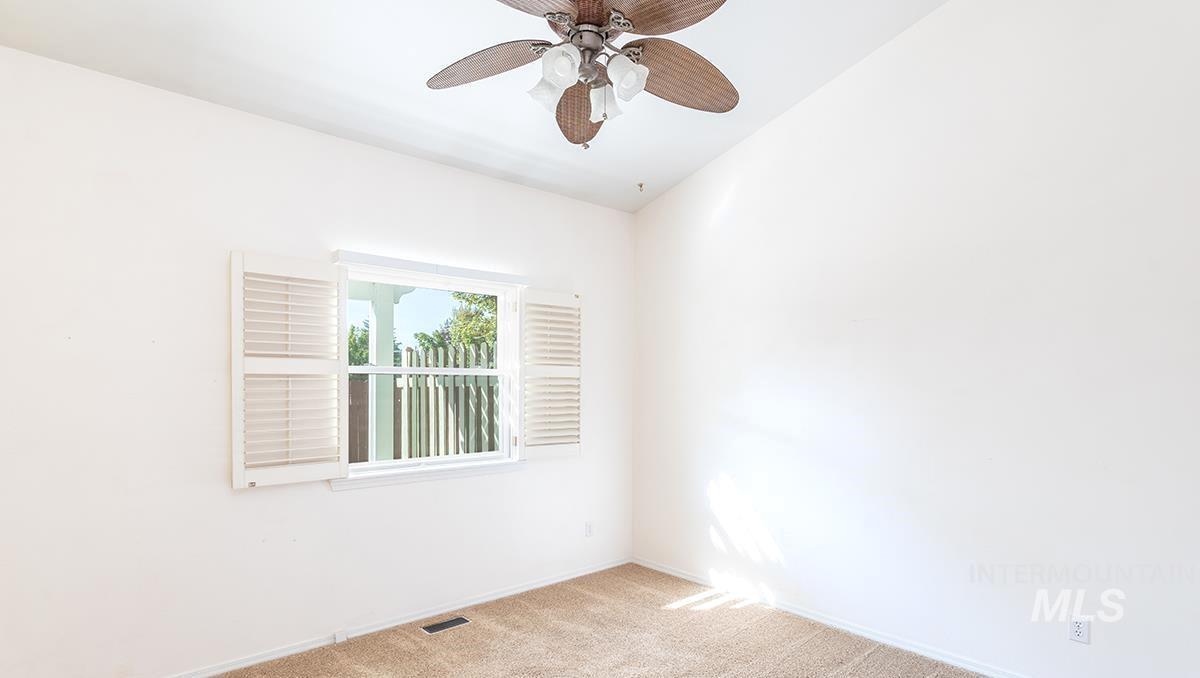 Unfurnished room with carpet and a ceiling fan