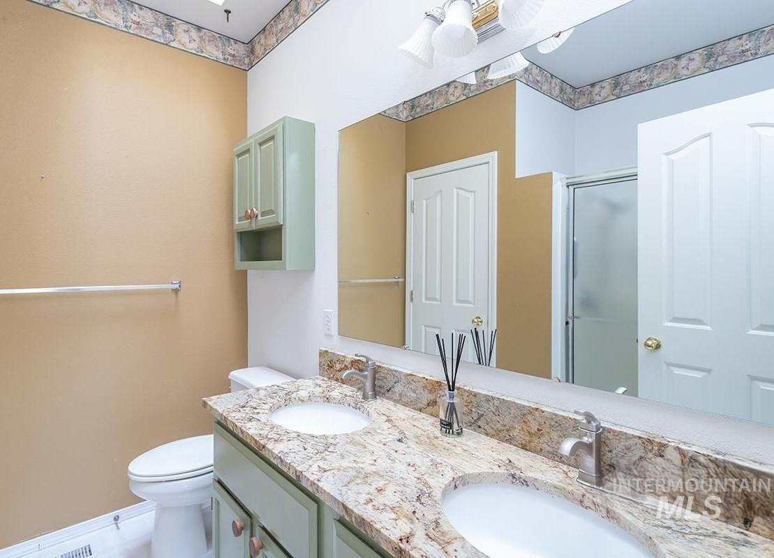 Bathroom featuring a shower stall and double vanity