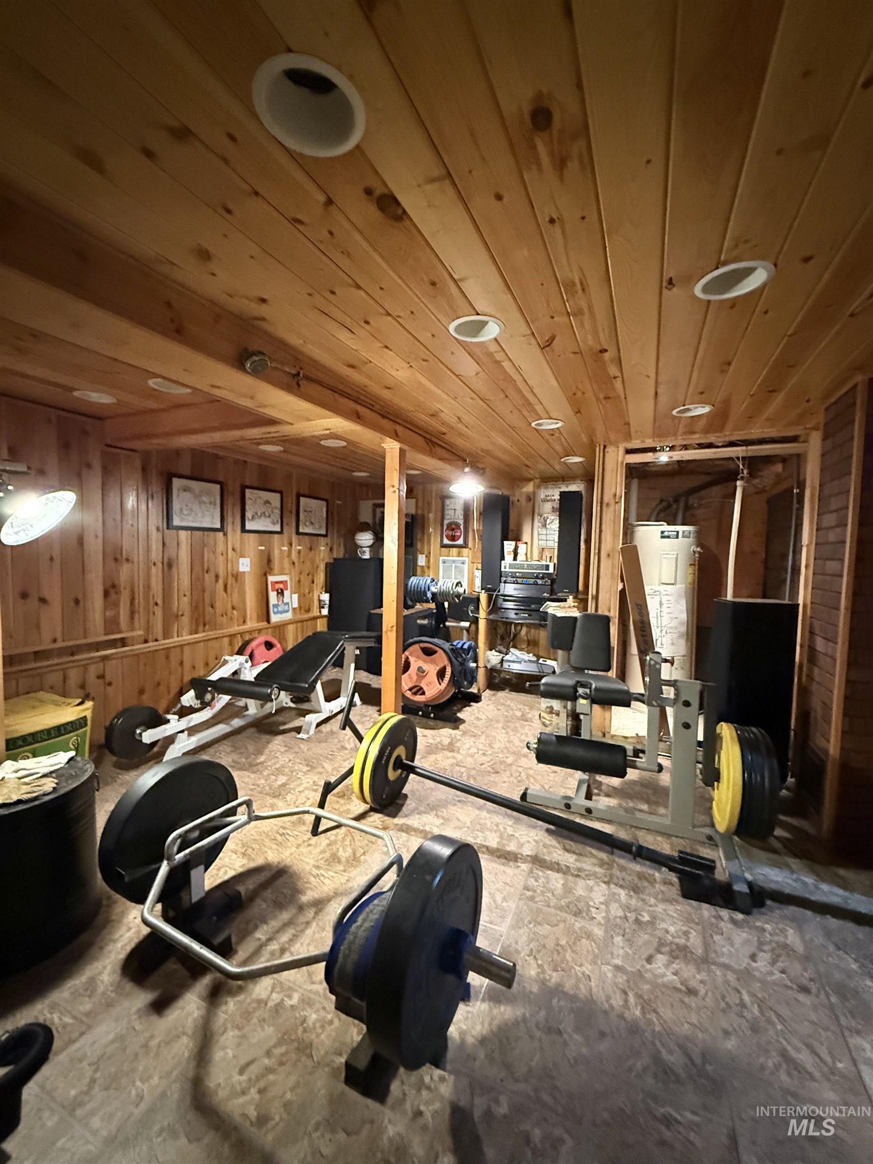 Workout area featuring wooden ceiling and wood walls