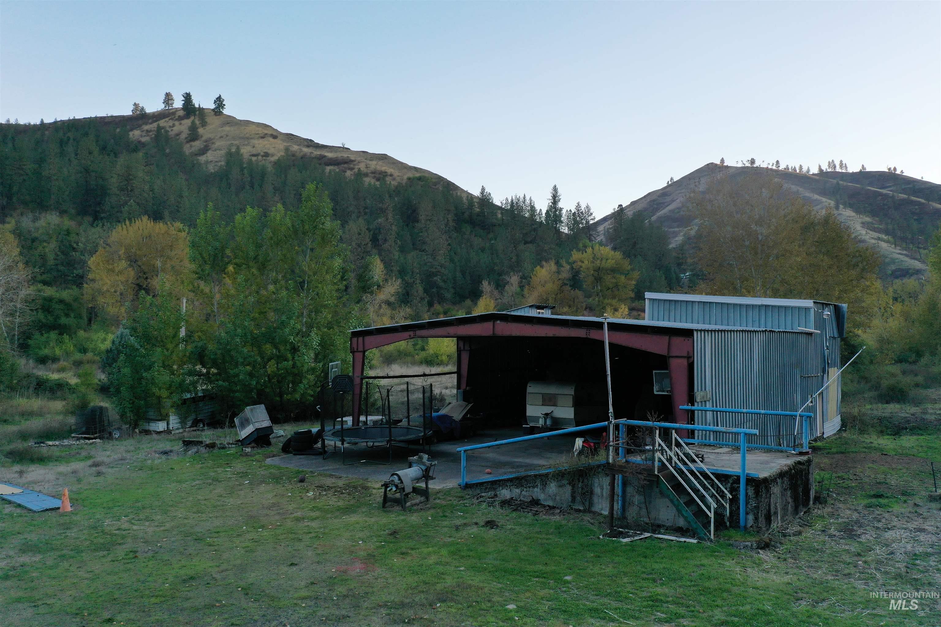 Back of house with a mountain view, an outbuilding, and a yard