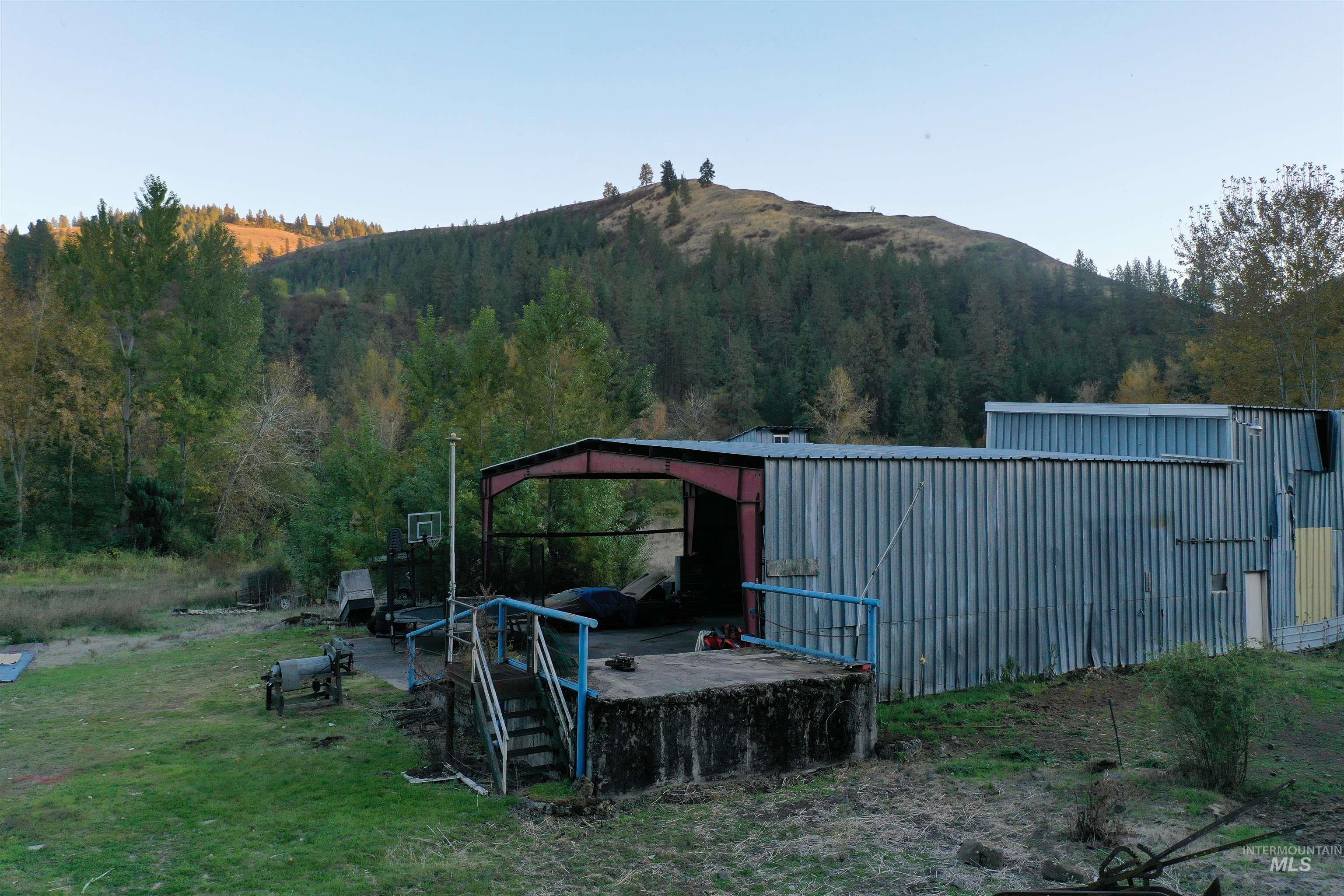 View of grassy yard featuring a mountain view, an outbuilding, and an outdoor structure