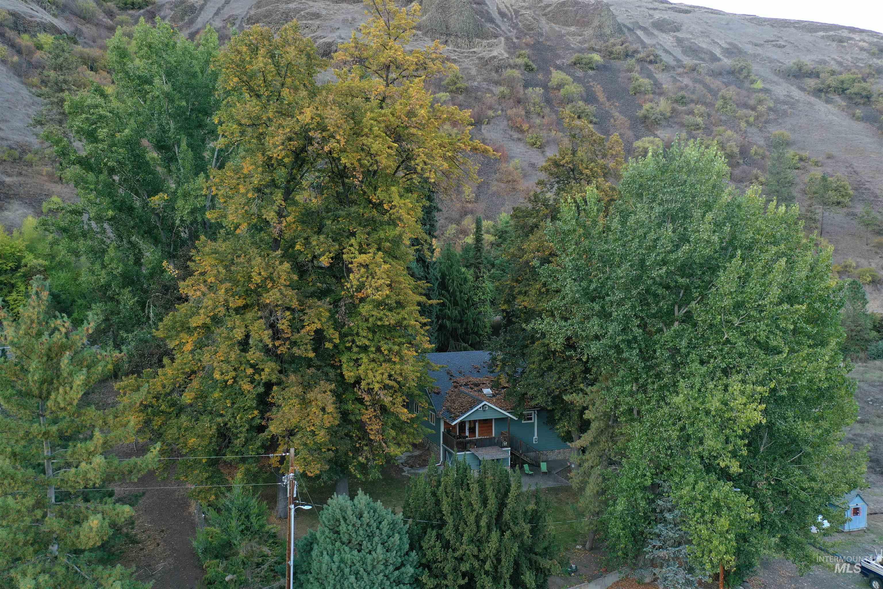 Aerial view of property and surrounding area featuring a mountainous background