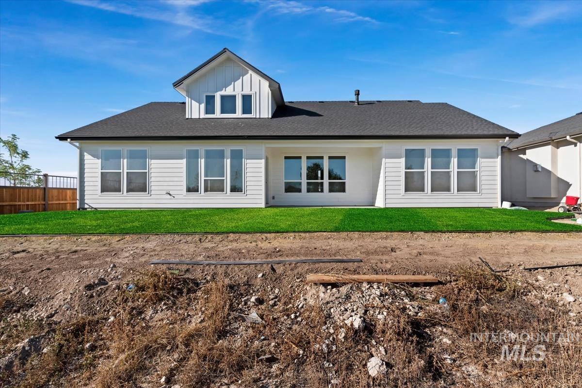 Rear exterior with white siding and a black shingle roof