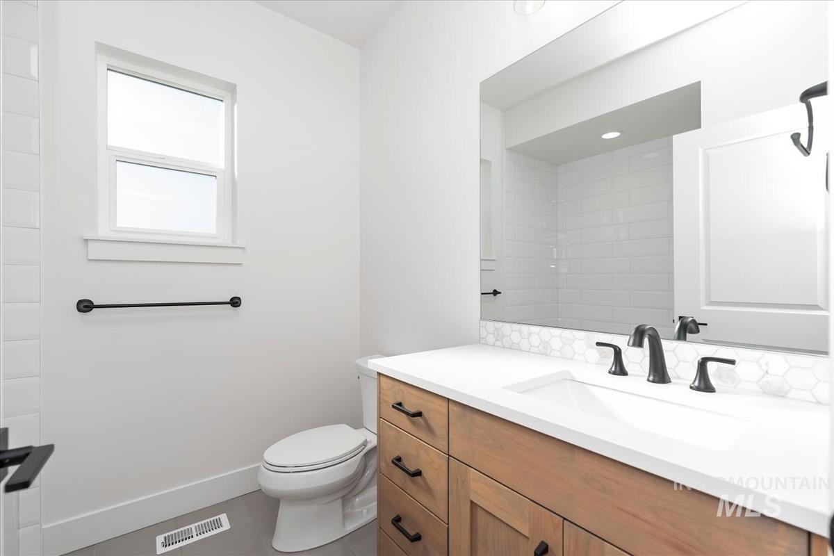 Contemporary bathroom featuring a wood-finish vanity with ample storage