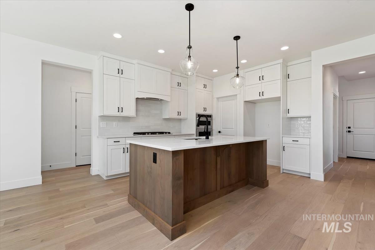Contemporary kitchen featuring a substantial wood-finish island with a white countertop and a black faucet