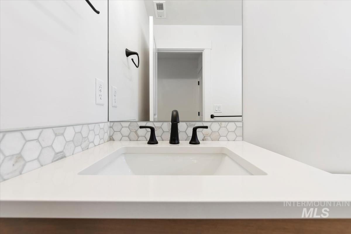 Integrated rectangular sink with a matte black faucet, set within a white solid surface countertop