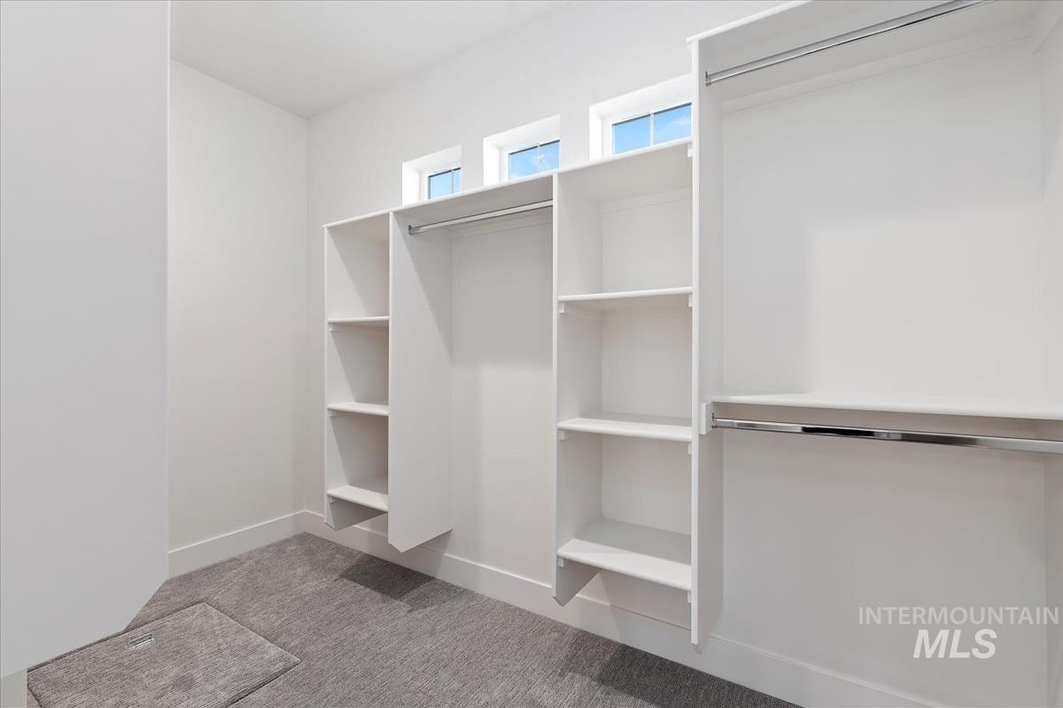 Built-in closet system featuring white shelving and chrome hanging rods