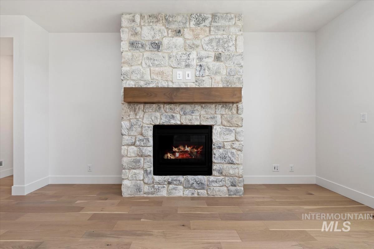Stone fireplace with a substantial wood mantel, featuring a black hearth