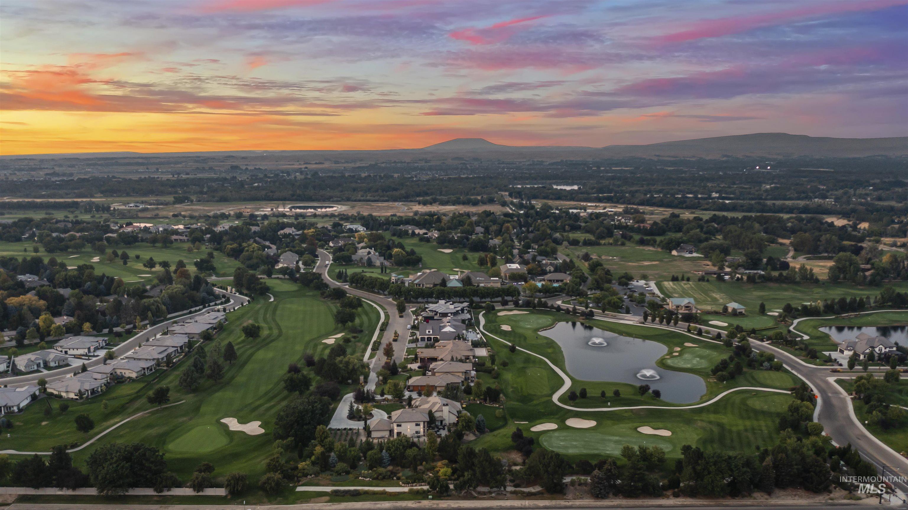 Aerial view of property and surrounding area with a water and mountain view and a golf course