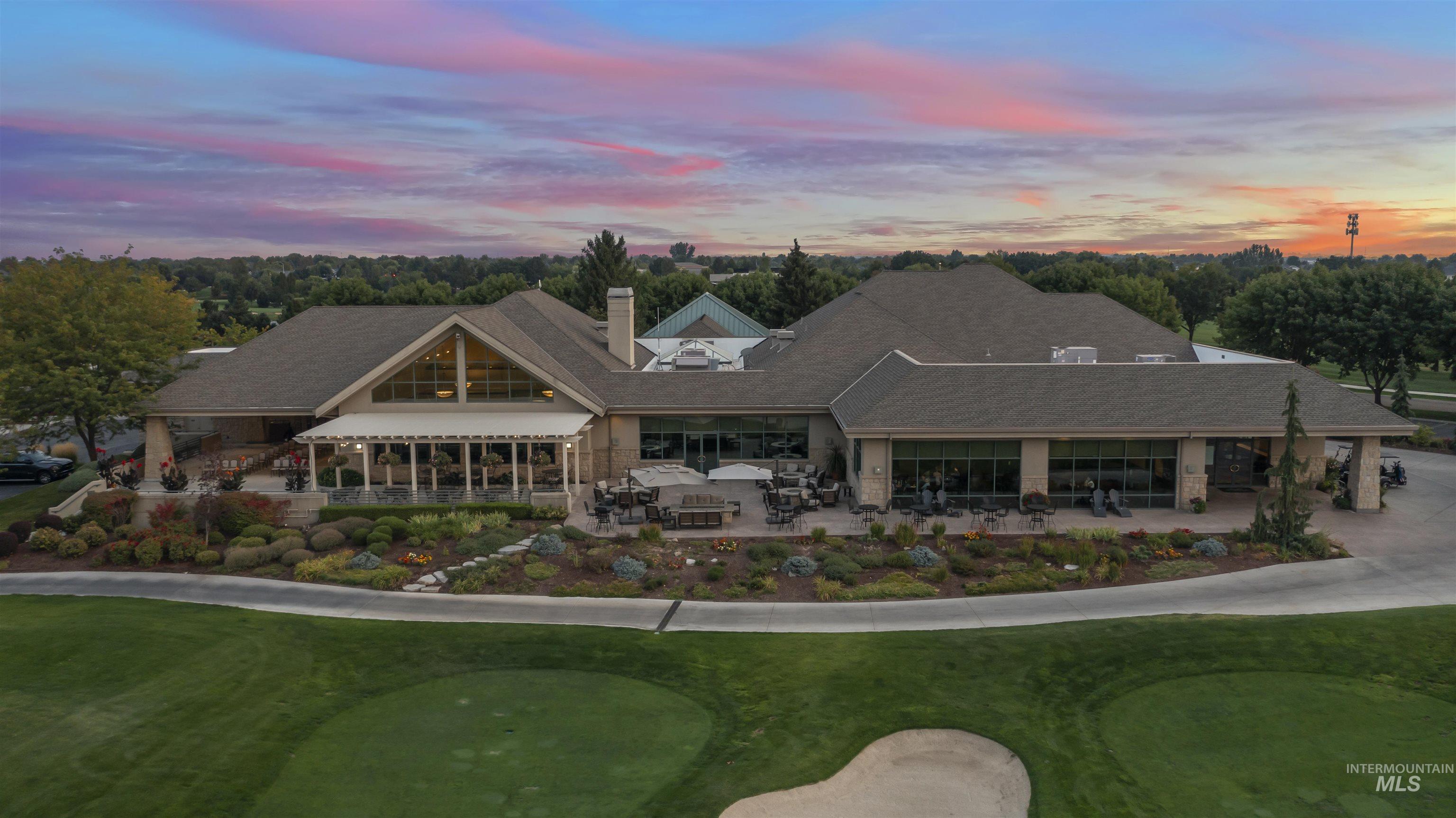 Rear view of property featuring a putting area, a patio, a chimney, and a yard
