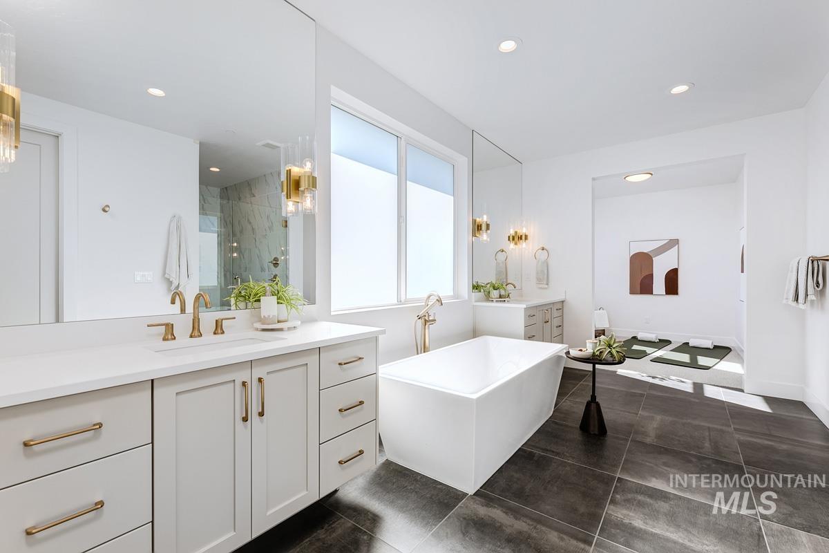 Full bathroom with two vanities, a soaking tub, a marble finish shower, recessed lighting, and dark tile patterned floors
