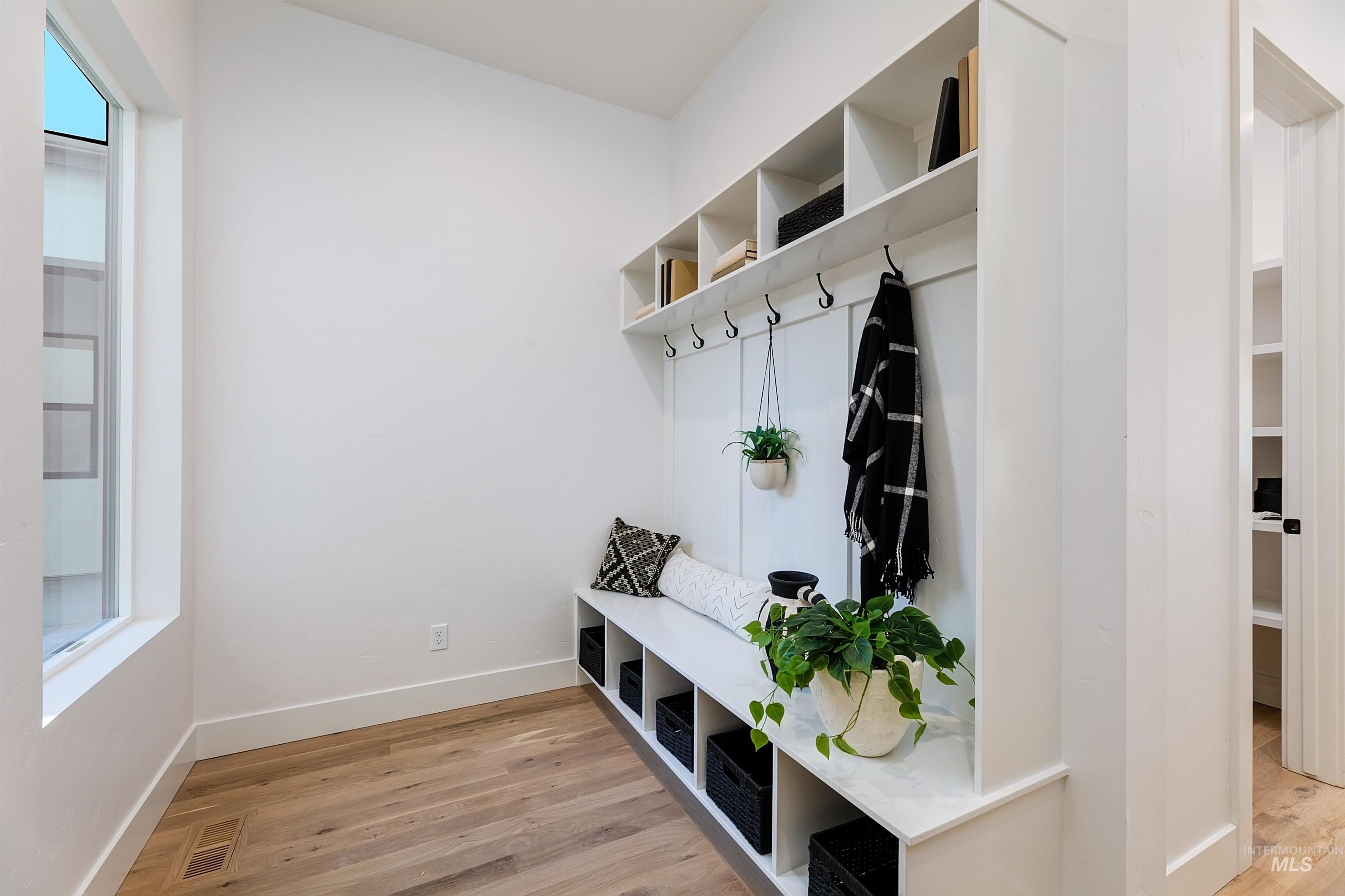 Mudroom featuring light wood-style floors and baseboards