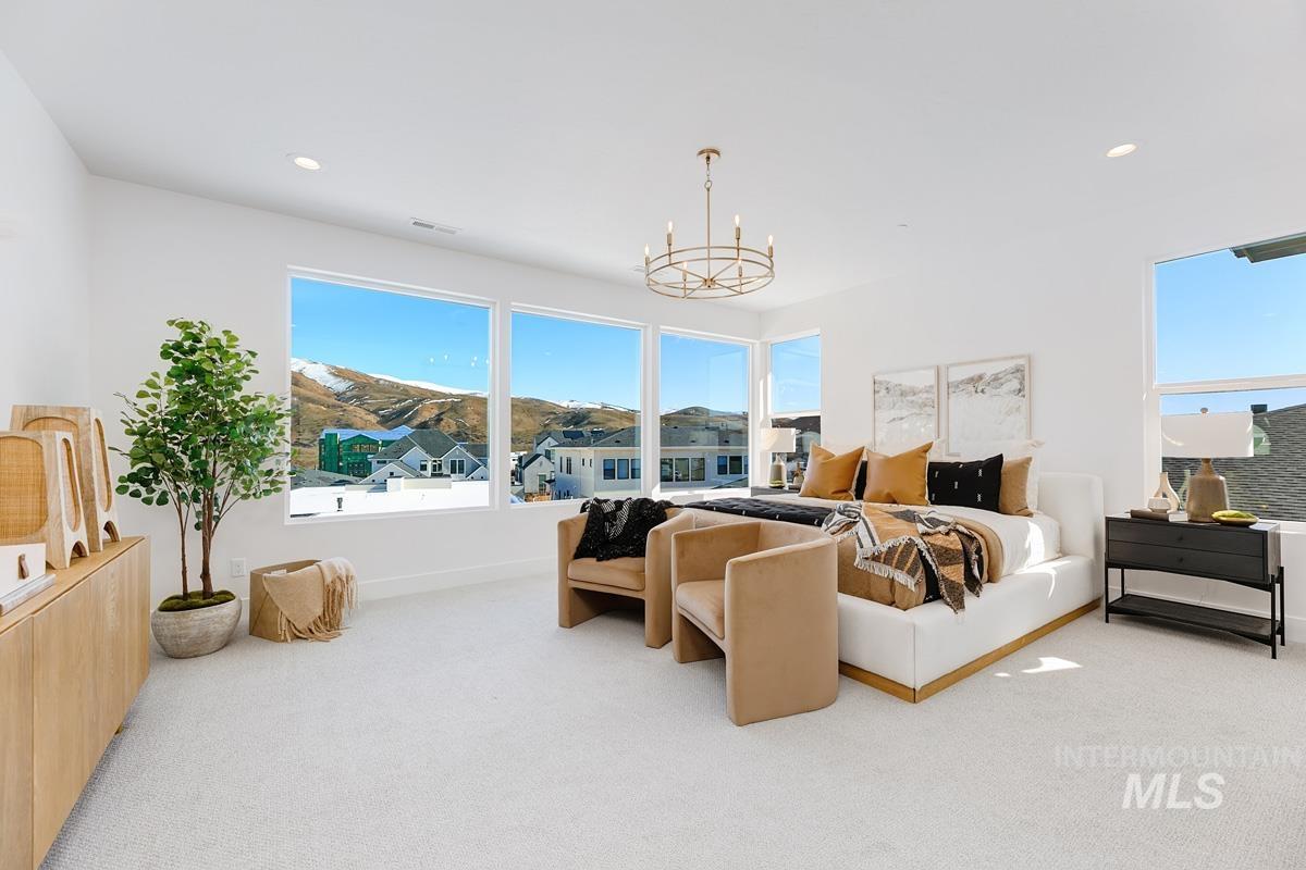 Bedroom with light colored carpet, a chandelier, and recessed lighting