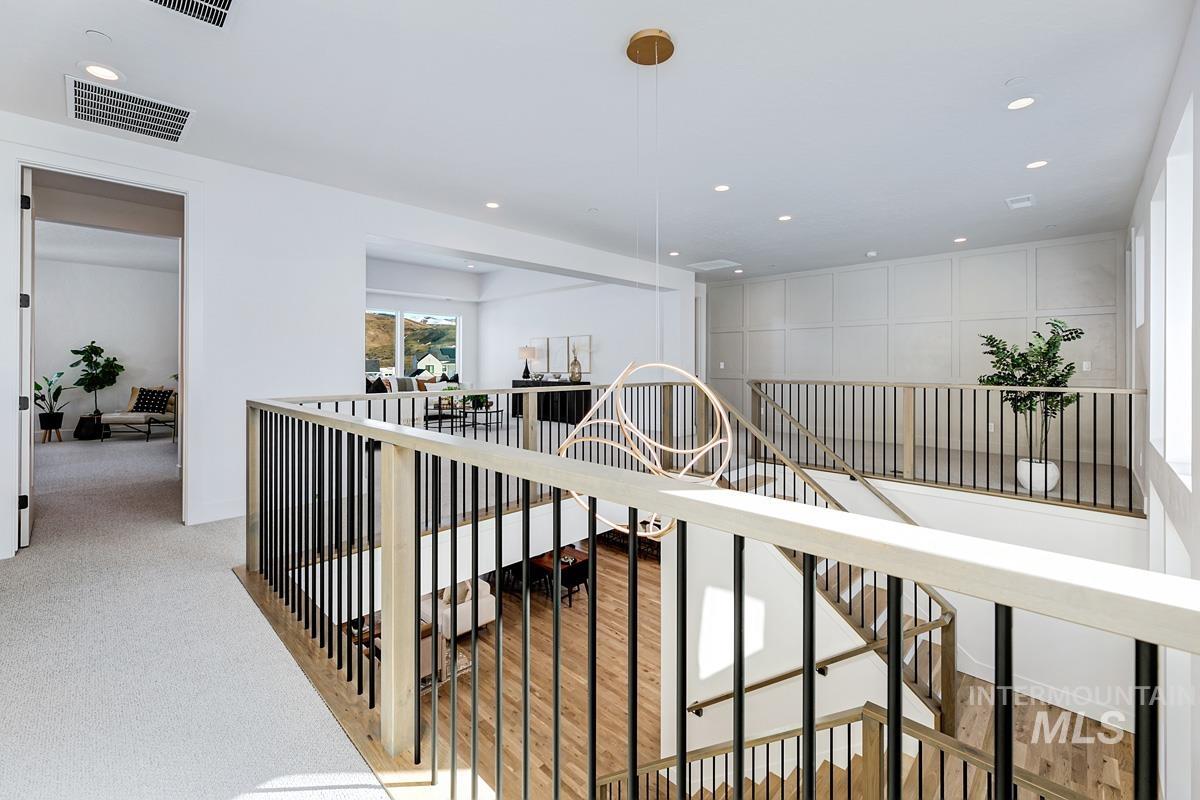 Corridor with an upstairs landing and recessed lighting