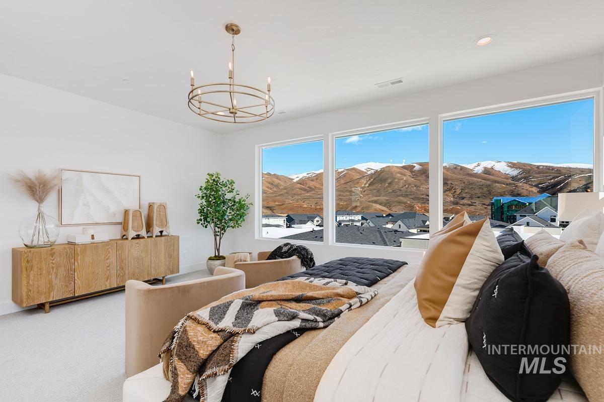 Carpeted bedroom with a chandelier and a mountain view