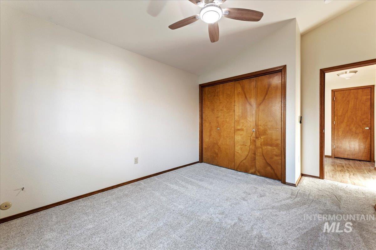 Unfurnished bedroom with carpet, a closet, and ceiling fan