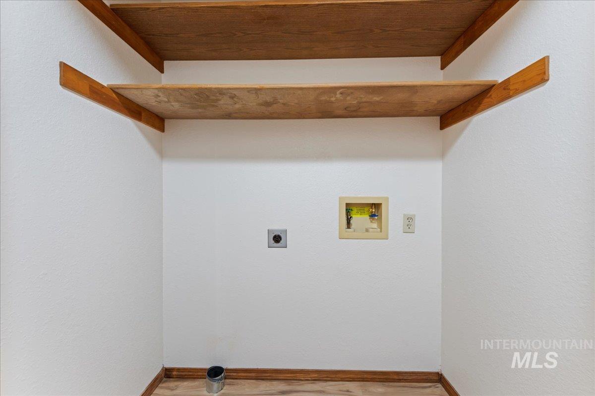 Laundry area featuring washer hookup, wood finished floors, hookup for an electric dryer, and a textured wall