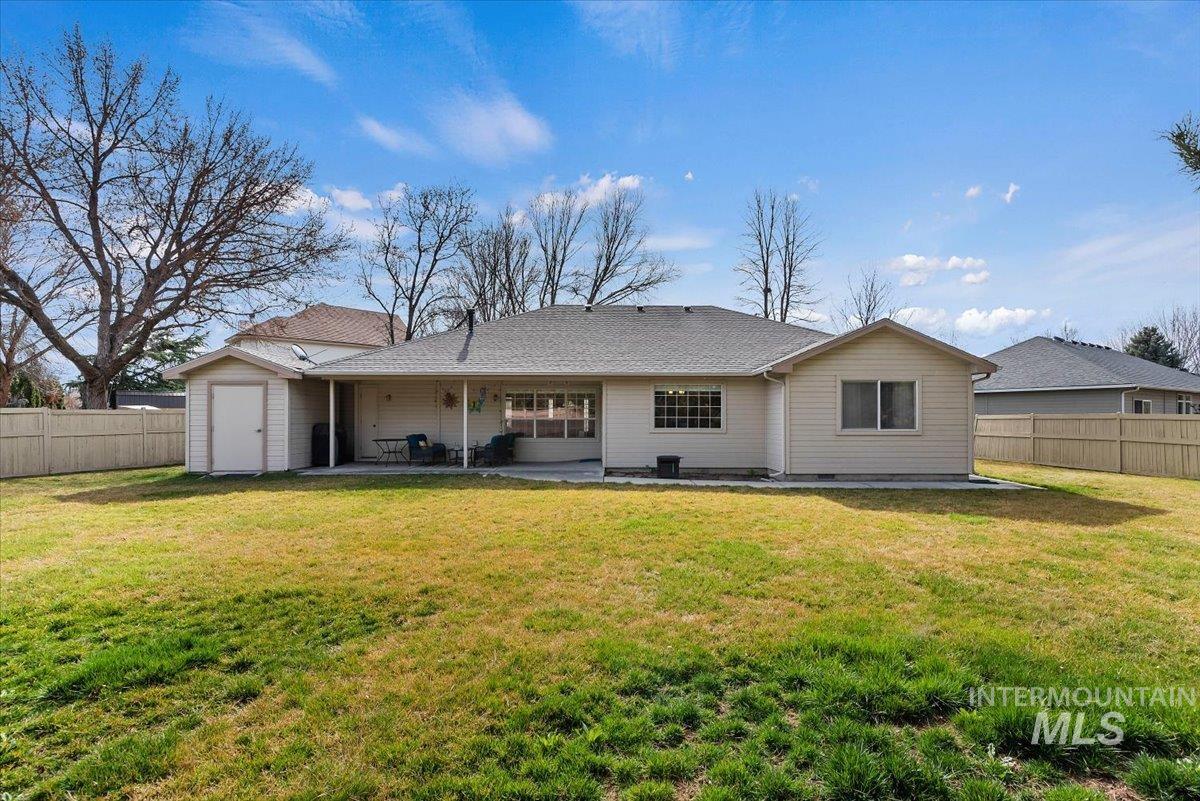 Rear view of property with a fenced backyard, a patio, and roof with shingles