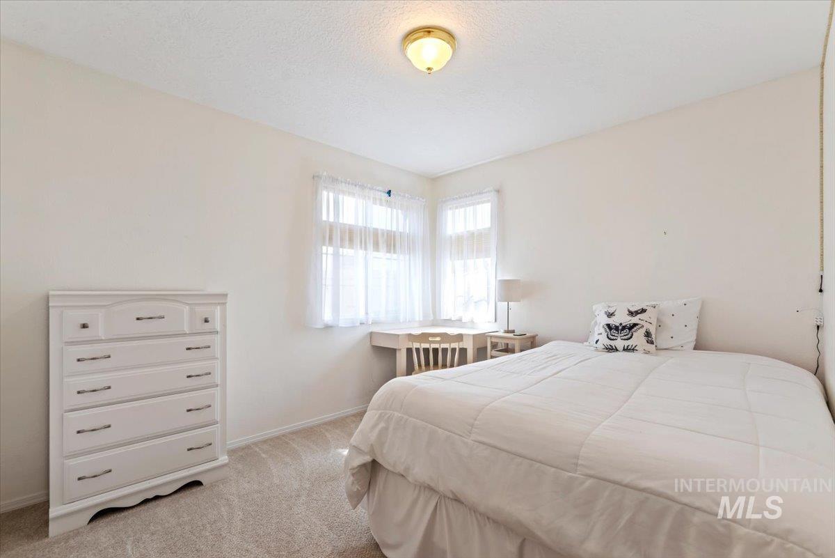 Bedroom featuring light colored carpet and a textured ceiling