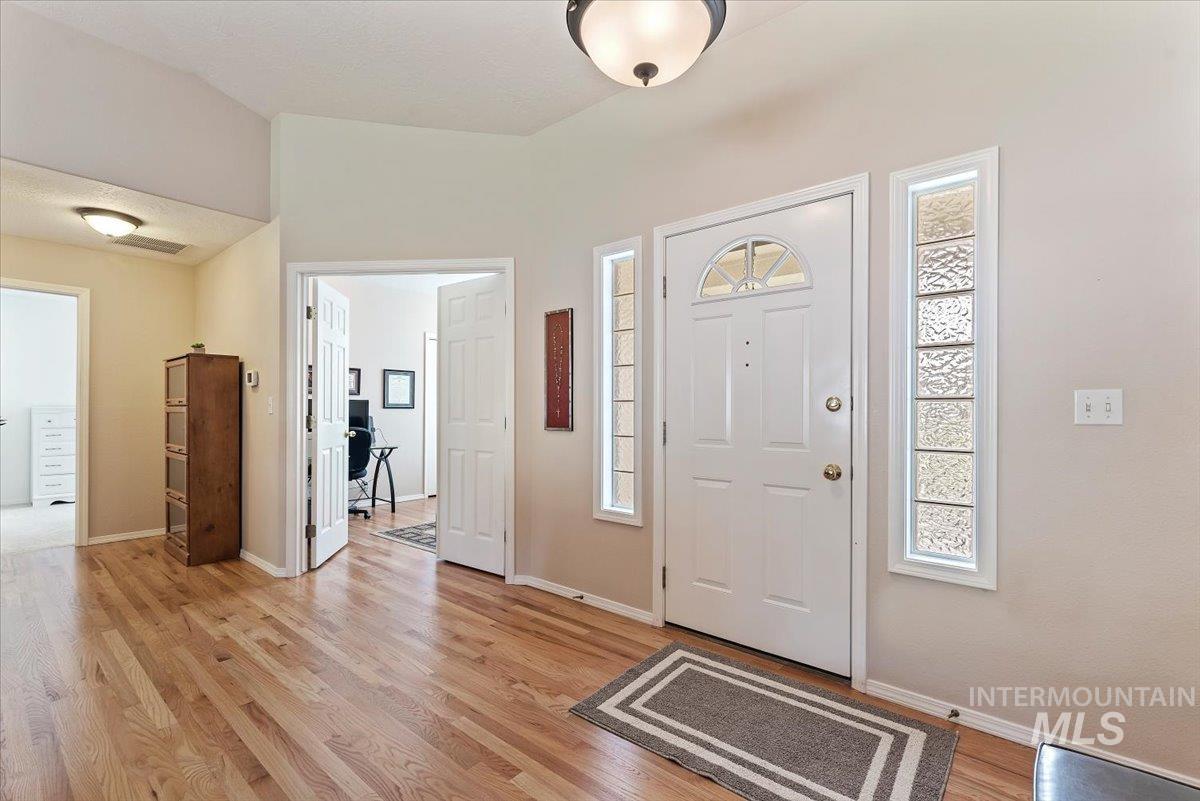 Foyer entrance with light wood-style flooring and baseboards
