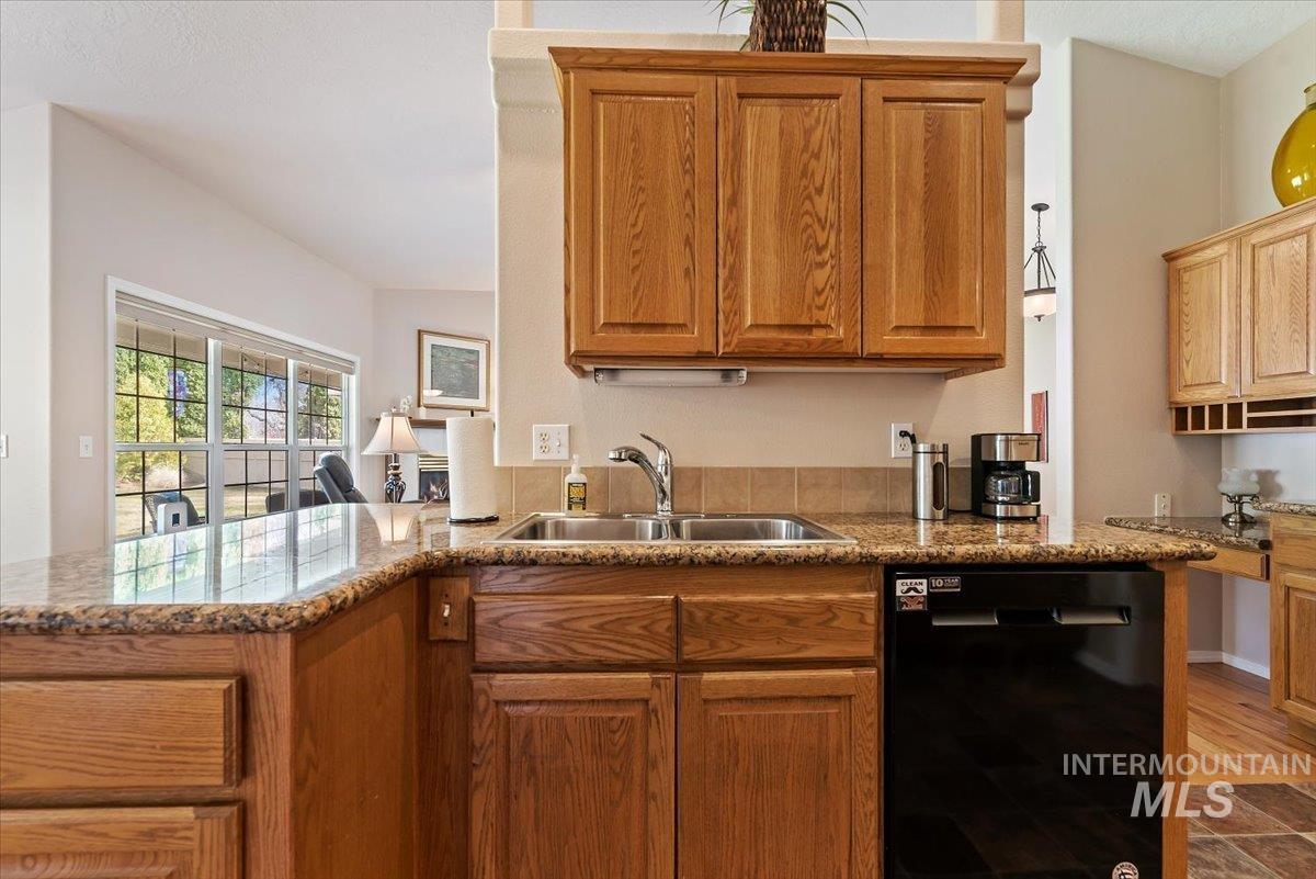 Kitchen featuring dishwasher, wood finish cabinetry, and a peninsula