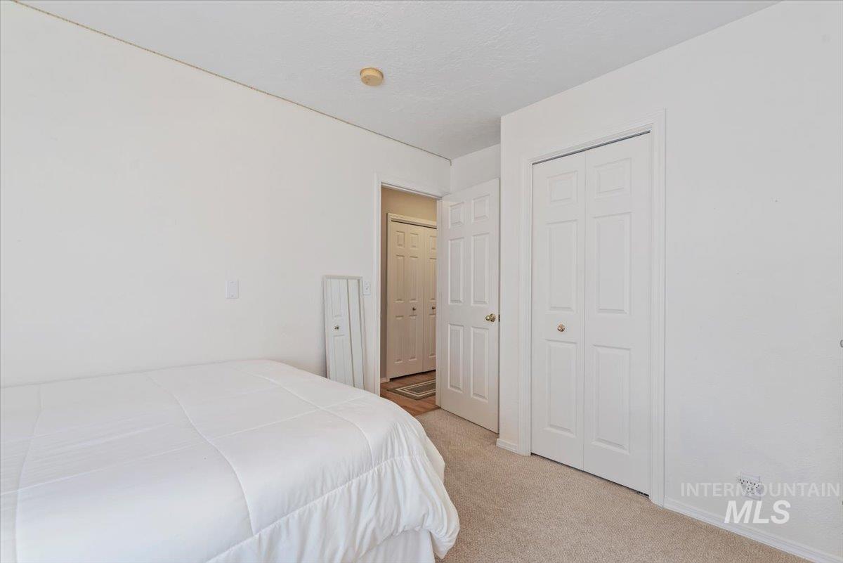 Bedroom with light carpet and a closet