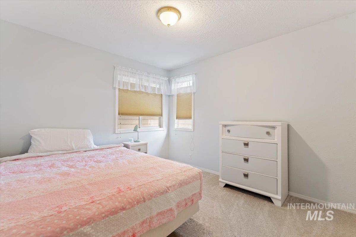 Bedroom with light carpet and a textured ceiling