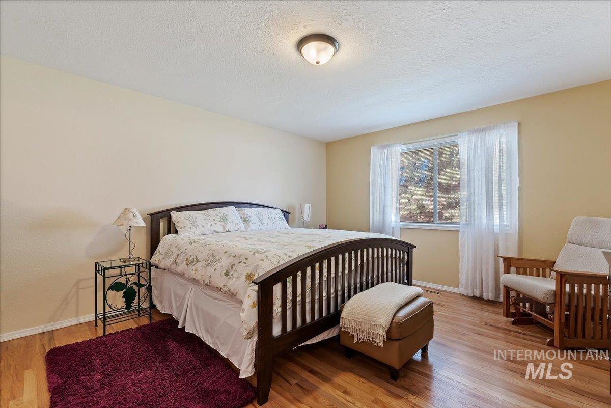 Bedroom featuring light wood finished floors and a textured ceiling