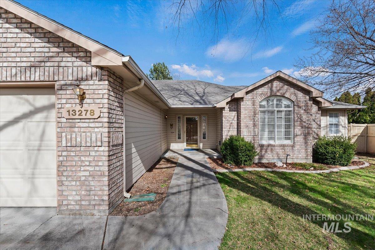 Property entrance with an attached garage and a yard