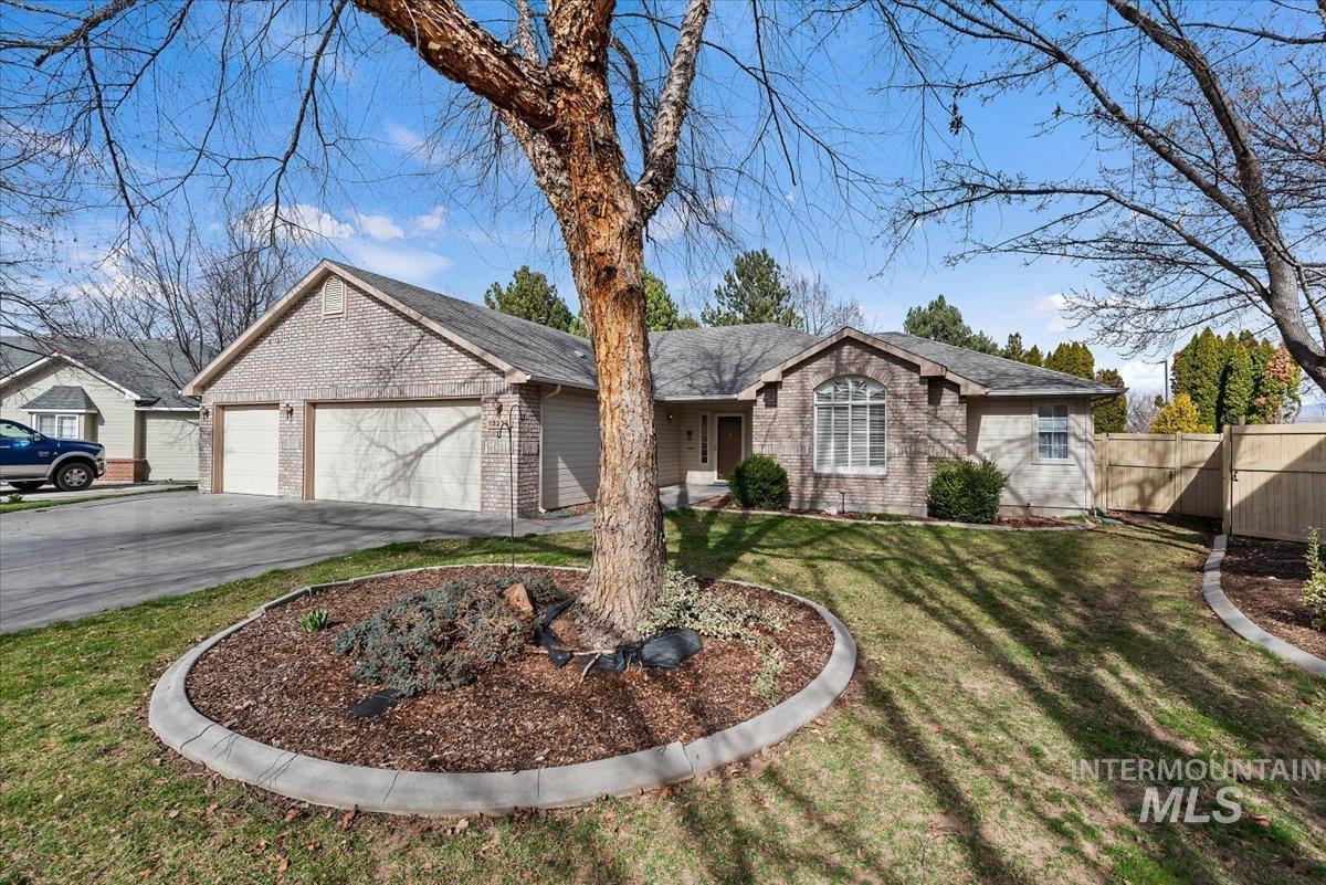 Single story home featuring a garage, driveway, and brick siding
