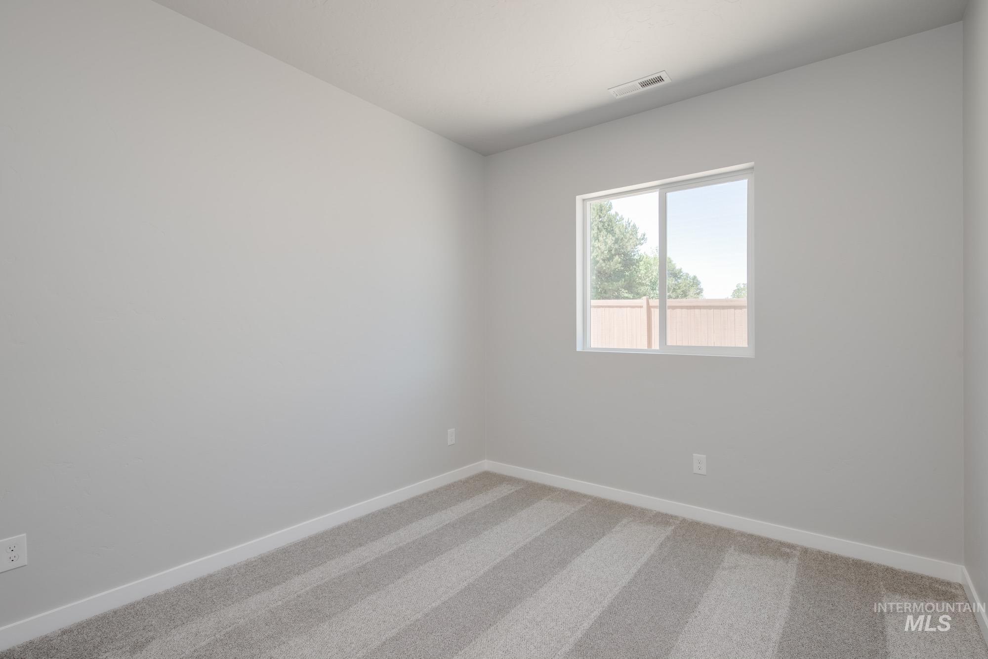 Unfurnished room with light carpet and baseboards