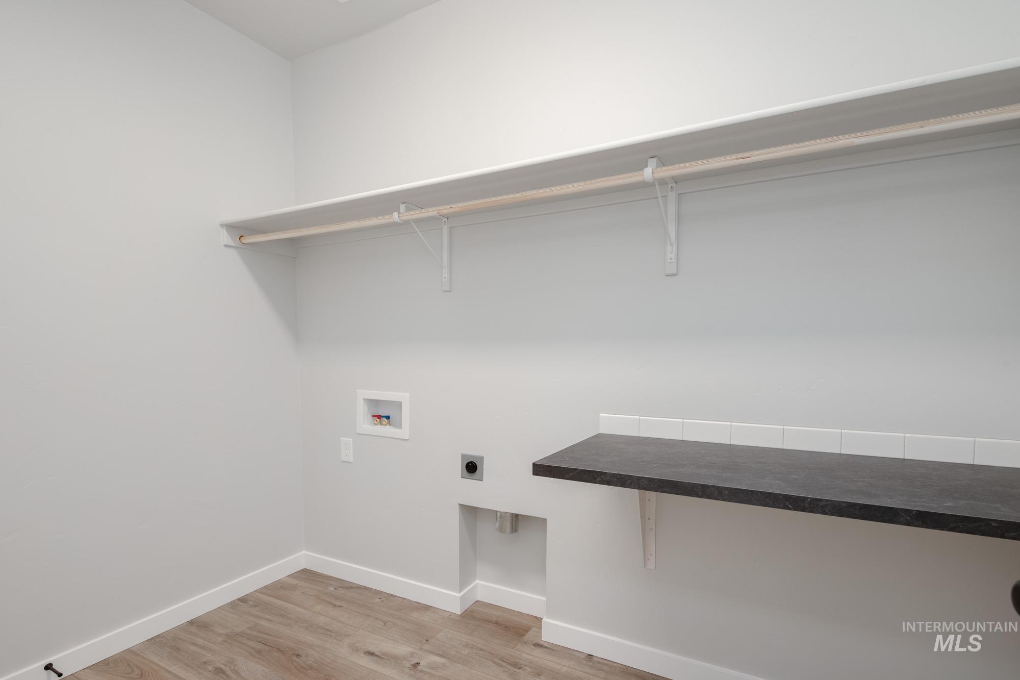 Laundry room featuring light wood-style flooring, electric dryer hookup, and hookup for a washing machine